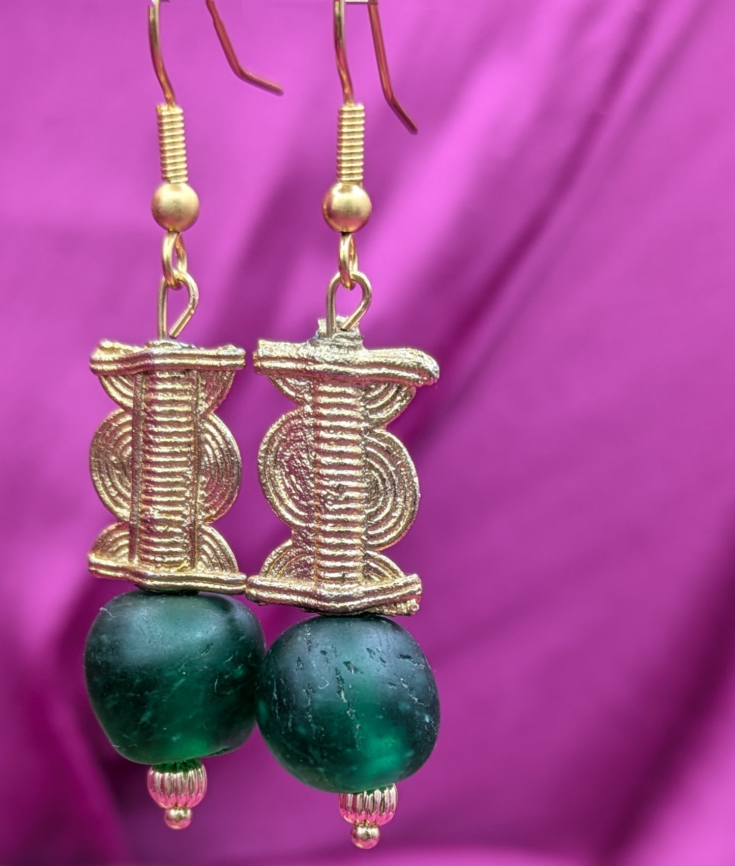 Boucles d'oreilles composées d'une perle translucide vert émeraude ainsi qu'une perle dorée ( poids Akan ) en laiton