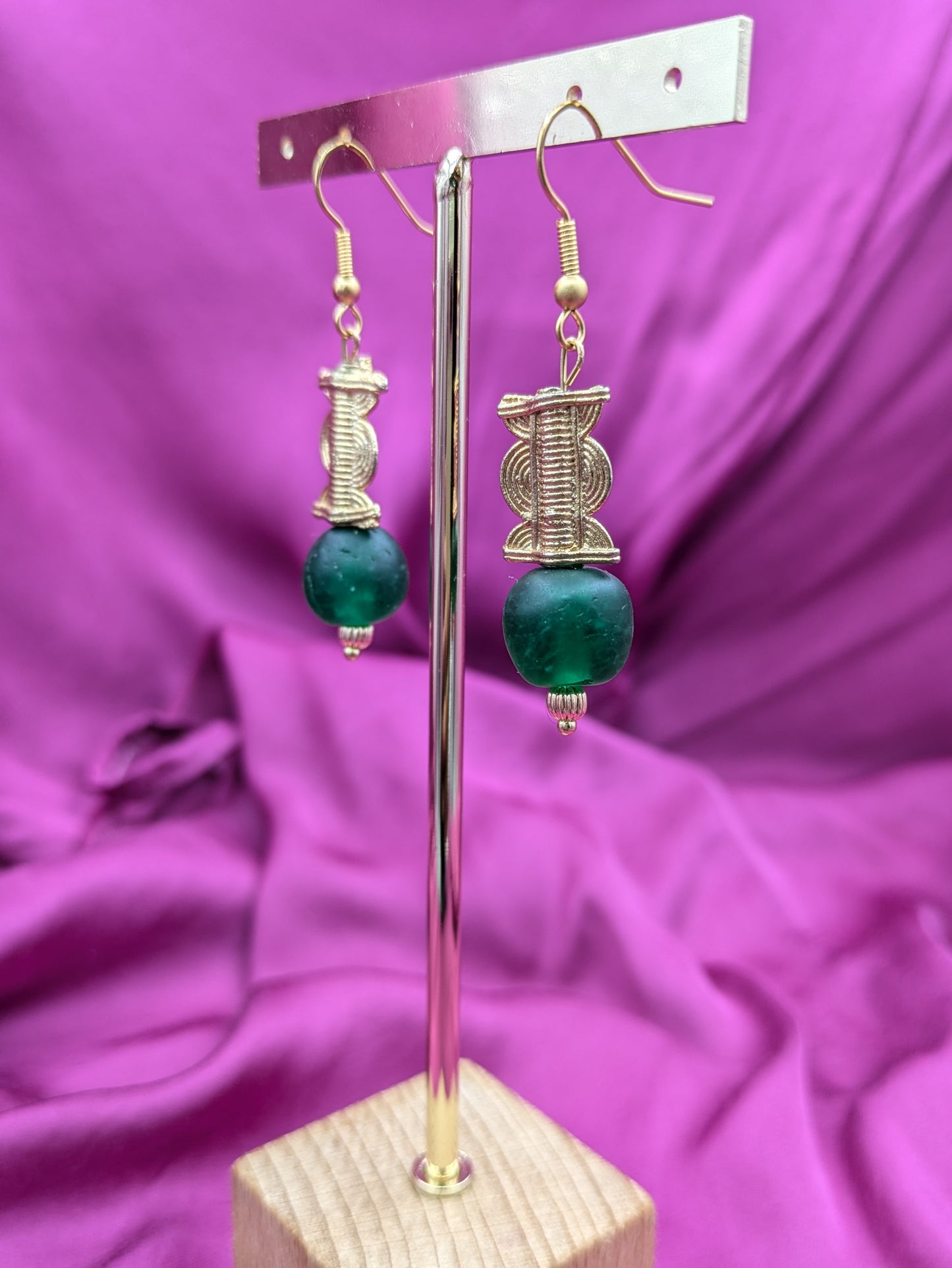 Boucles d'oreilles composées d'une perle translucide vert émeraude ainsi qu'une perle dorée ( poids Akan ) en laiton