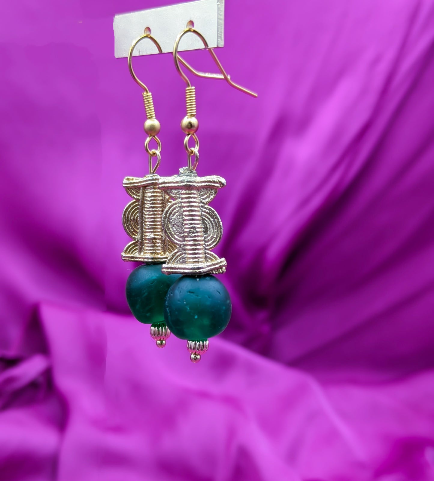 Boucles d'oreilles composées d'une perle translucide vert émeraude ainsi qu'une perle dorée ( poids Akan ) en laiton