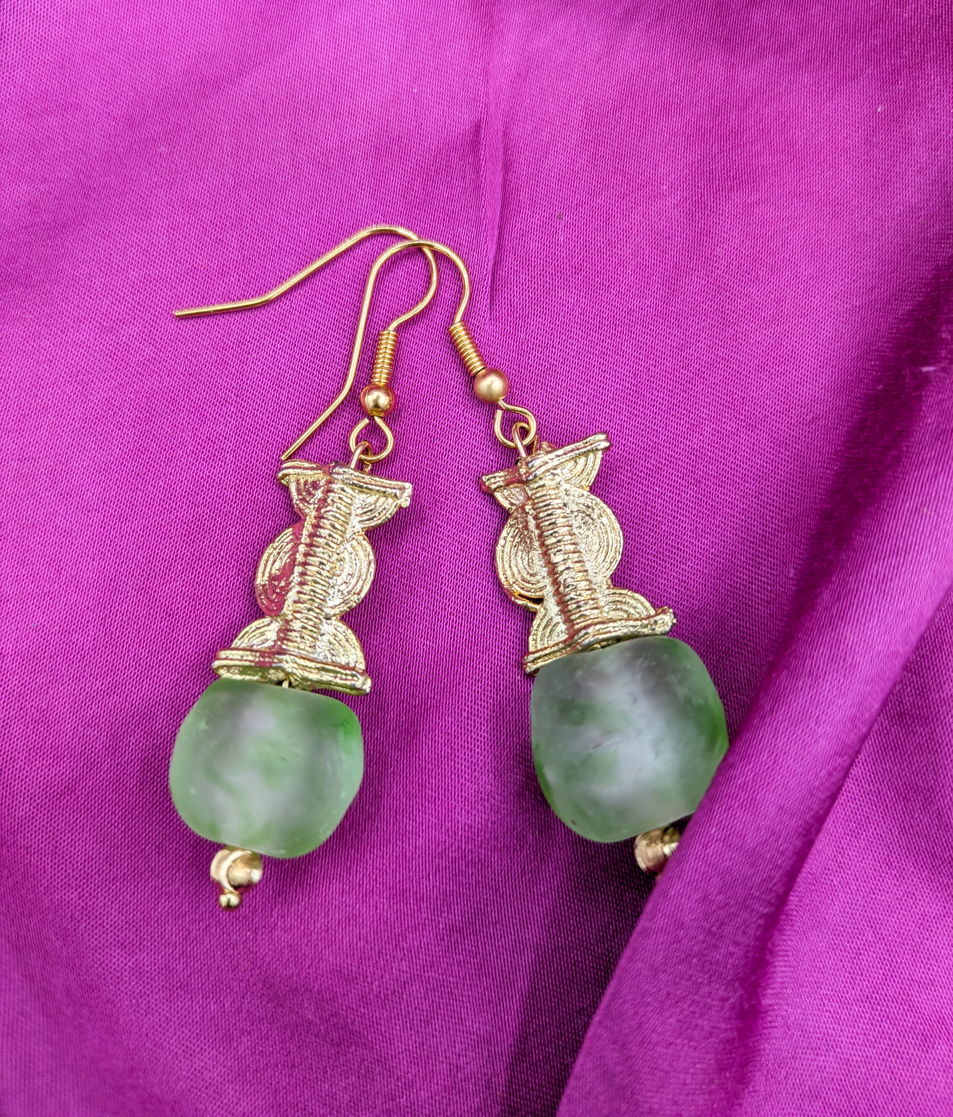 Boucles d'oreilles composées d'une perle translucide vertes d'eau ainsi qu'une perle dorée ( poids Akan ) en laiton.