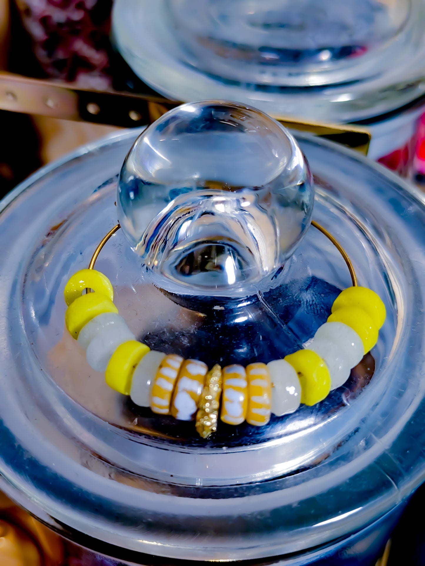 "Boucles d'oreilles créoles avec perles africaines en verre recyclé jaune fluo et blanc, décorées de rayures blanches et jaunes."