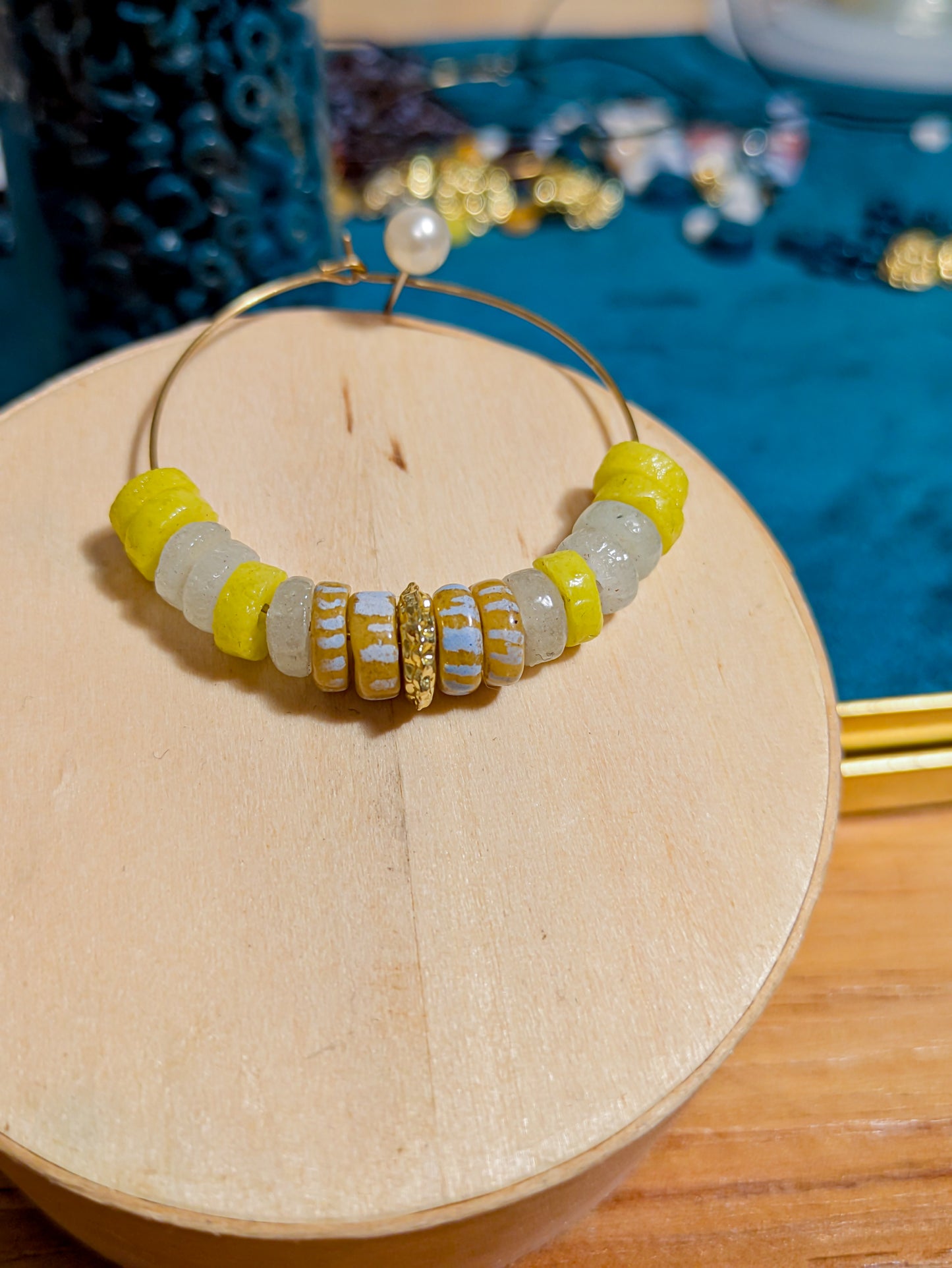 "Boucles d'oreilles créoles avec perles africaines en verre recyclé jaune fluo et blanc, décorées de rayures blanches et jaunes."