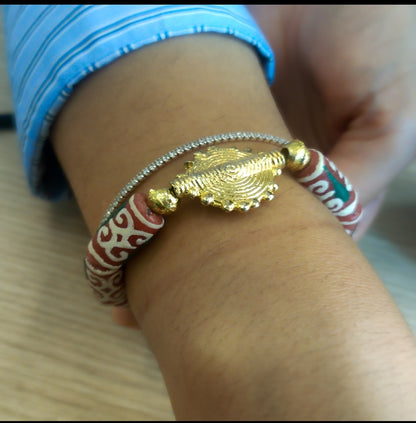 Bracelet avec perles rouges qui arborent un motif africain riche de significations : le "Dwennimen", qui signifie "cornes de bélier".
