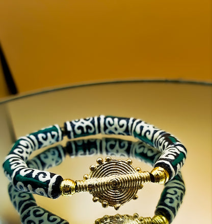Bracelet avec perles vertes qui arborent un motif africain riche de significations : le "Dwennimen", qui signifie "cornes de bélier".