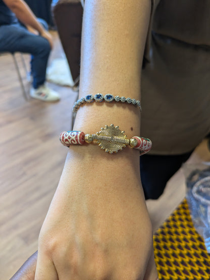 Bracelet avec perles rouges qui arborent un motif africain riche de significations : le "Dwennimen", qui signifie "cornes de bélier".