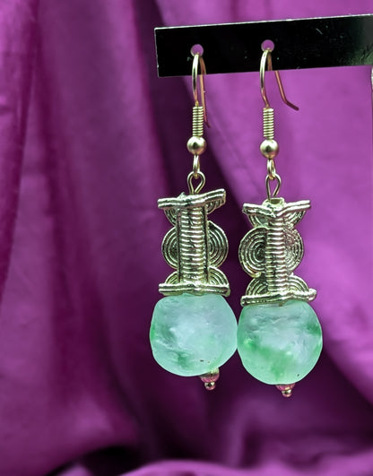 Boucles d'oreilles composées d'une perle translucide vertes d'eau ainsi qu'une perle doré ( poids Akan ) en laiton. 
