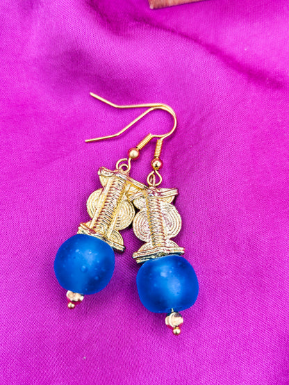 Boucles d'oreilles composées d'une perle translucide bleue turquoise ainsi qu'une perle doré ( poids Akan ) en laiton. 