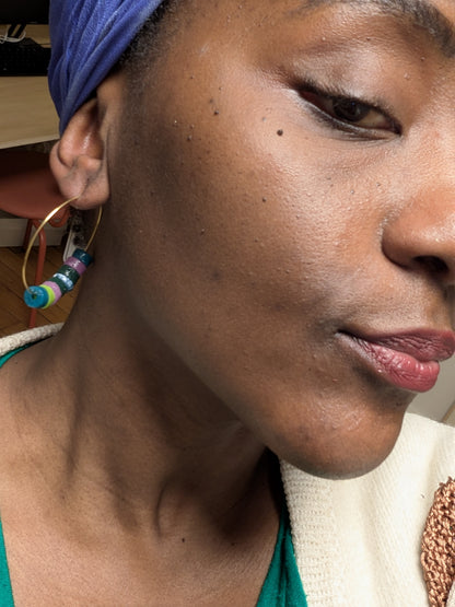 " Boucles d'oreilles créoles avec perles africaines en verre recyclé avec une variété de perles vertes et violettes en acier inoxydable"