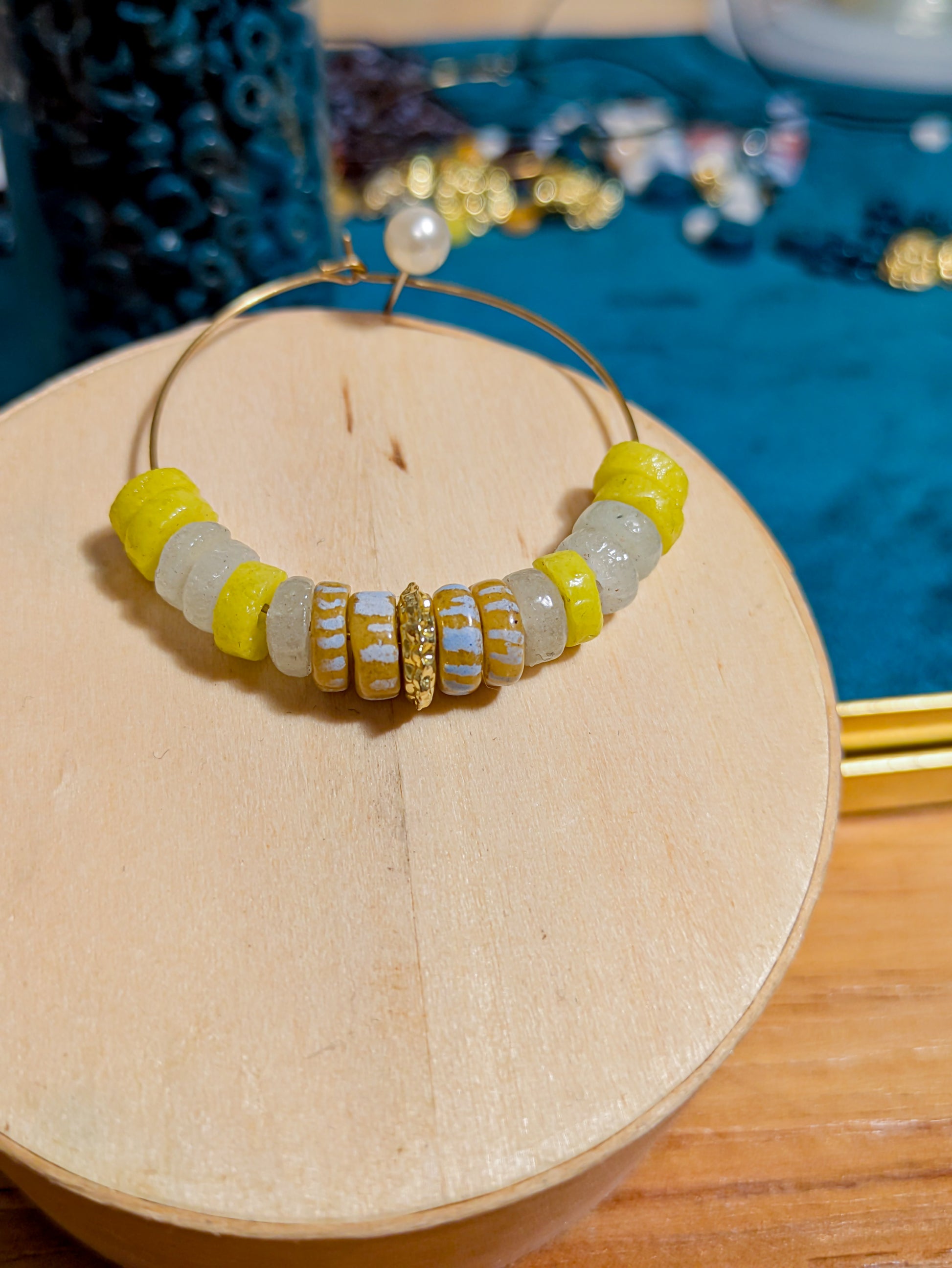 "Boucles d'oreilles créoles avec perles africaines en verre recyclé jaune fluo et blanc, décorées de rayures blanches et jaunes."