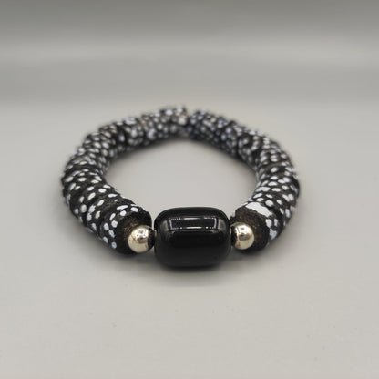 Ce bracelet bleu, réalisé artisanalement à partir de perles de verres recyclés est composé de perles bleues à pois, surmonté d'une perle noir et deux petites perles en argent.
